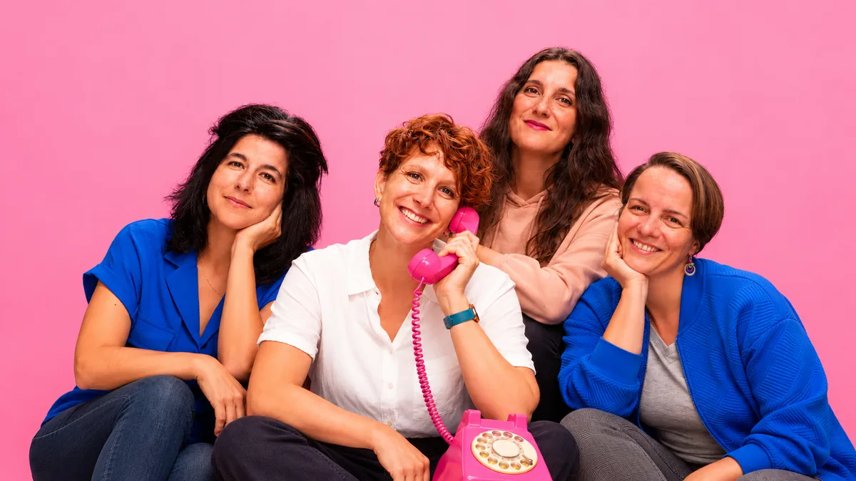 Quatre mamans de l'équipe des Fabuleuses, assises ensemble, l'une le combiné d'un téléphone rose à l'oreille