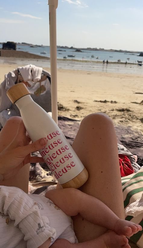 Une gourde « Fabuleuse » posée à la plage, au bord de l'eau