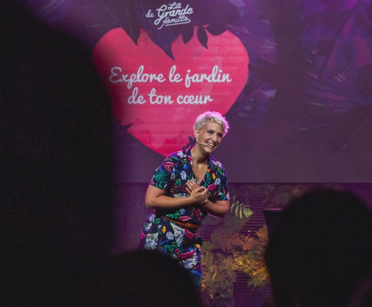 Hélène sur scène devant un écran « Explore le jardin de ton cœur »